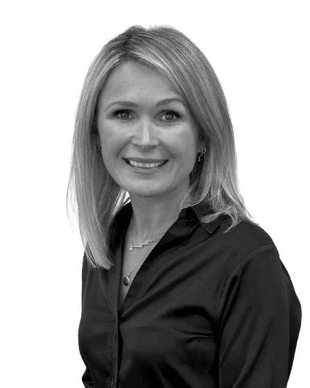 A black & white image of a staff member (A woman smiling)