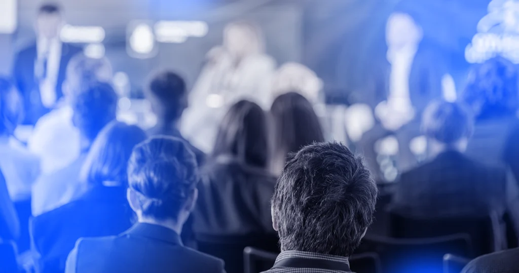 people in the audience watching a conference